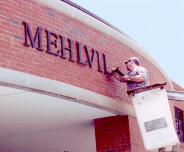 A worker places new letters on the front of Mehlville Senior High School as one of the final touches of Proposition P improvements at the school. Prop P was approved by voters in 2000, and was one of the last times Mehlville made a significant investment in its facilties. 