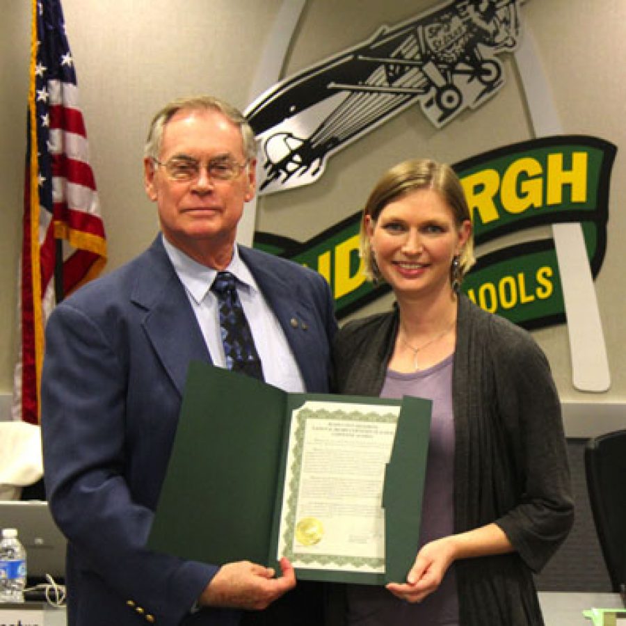 Lindbergh Schools Board of Education President Vic Lenz presents a resolution to Christine Anthes. Anthes recently completed the National Board Teachers Certification process.