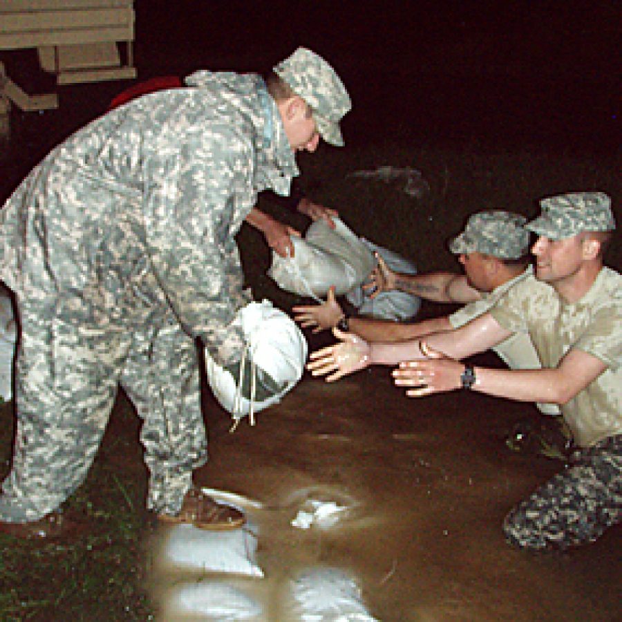 Members of the 1138th Military Police Company assist Butler County officials in sandbagging a ditch drain near the Poplar Bluff armory to prevent water from draining into area where the county is pumping out water. M. Queiser/Missouri National Guard photo
