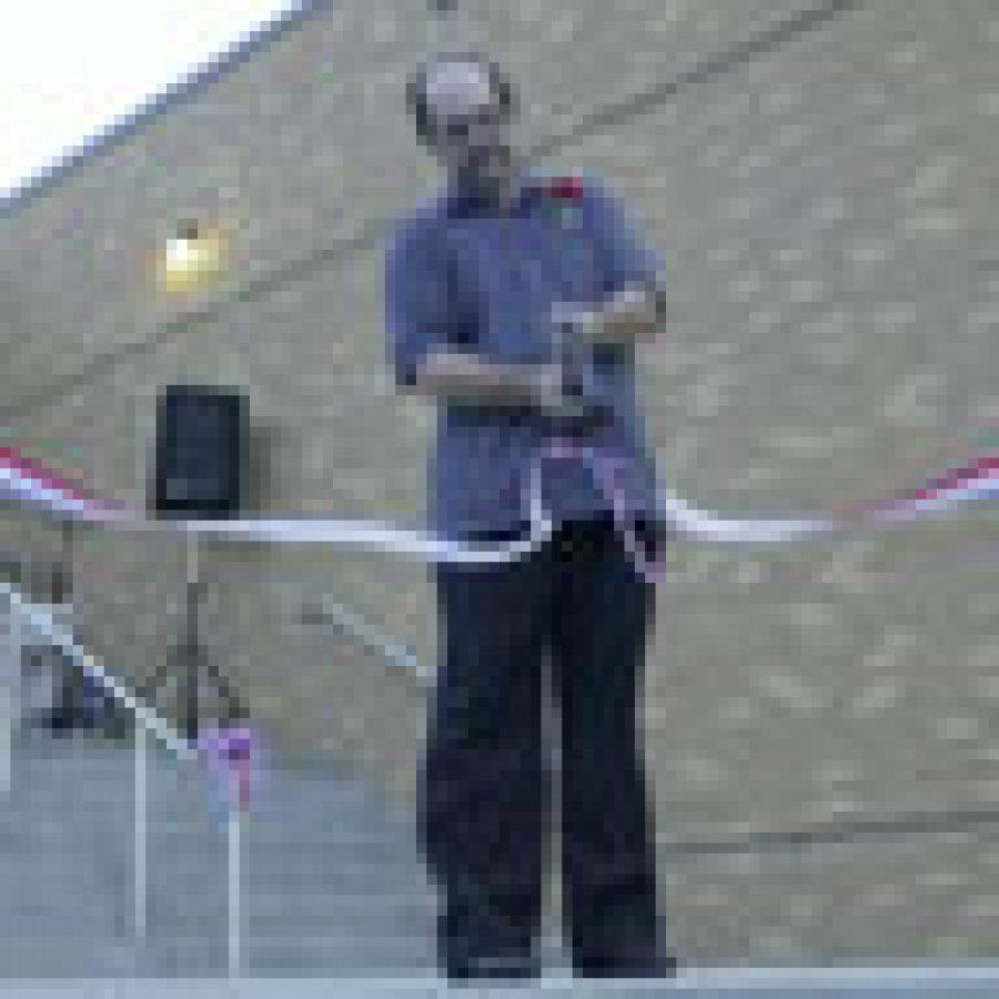 Head custodian Dave Taylor cuts the ribbon marking the grand re-opening of Washington Middle School. Taylor was recognized for service above and beyond the call of duty during the construction process.