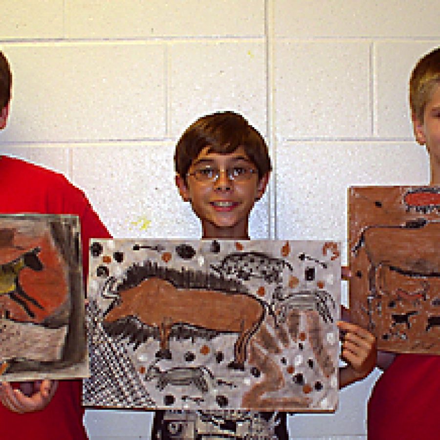 Oakville Middle School sixth graders, from left, Jon Hummer, Nick Engel and Stephen Reddick, display their artwork to be featured at the school's exhibition at Midwest BankCentre on Telegraph Road. This year marks the second year the school and bank have partnered to create an art exhibition for the community to view.