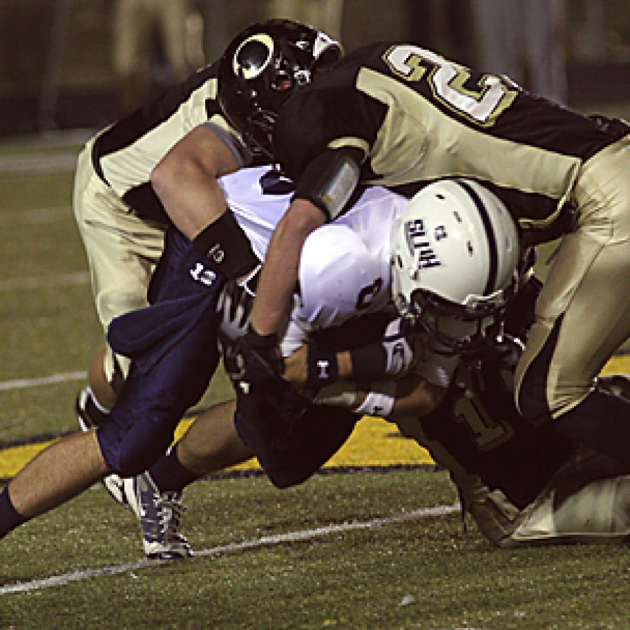 St. Louis University High tight end Bill Weiss fights for an extra yard as Oakville linebackers Phil Schneider and Jake Julius take him down Friday night in the Tigers sectional victory. Stephen Glover photo
