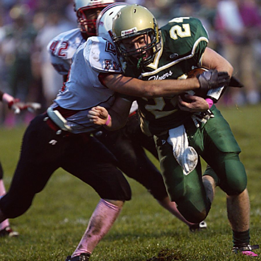 Lindbergh High School running back Brett Gallagher, 24, breaks a tackle by Foxs Tyler Rhodes during first-quarter action Friday as the Flyers won their third game of the season 21-12.