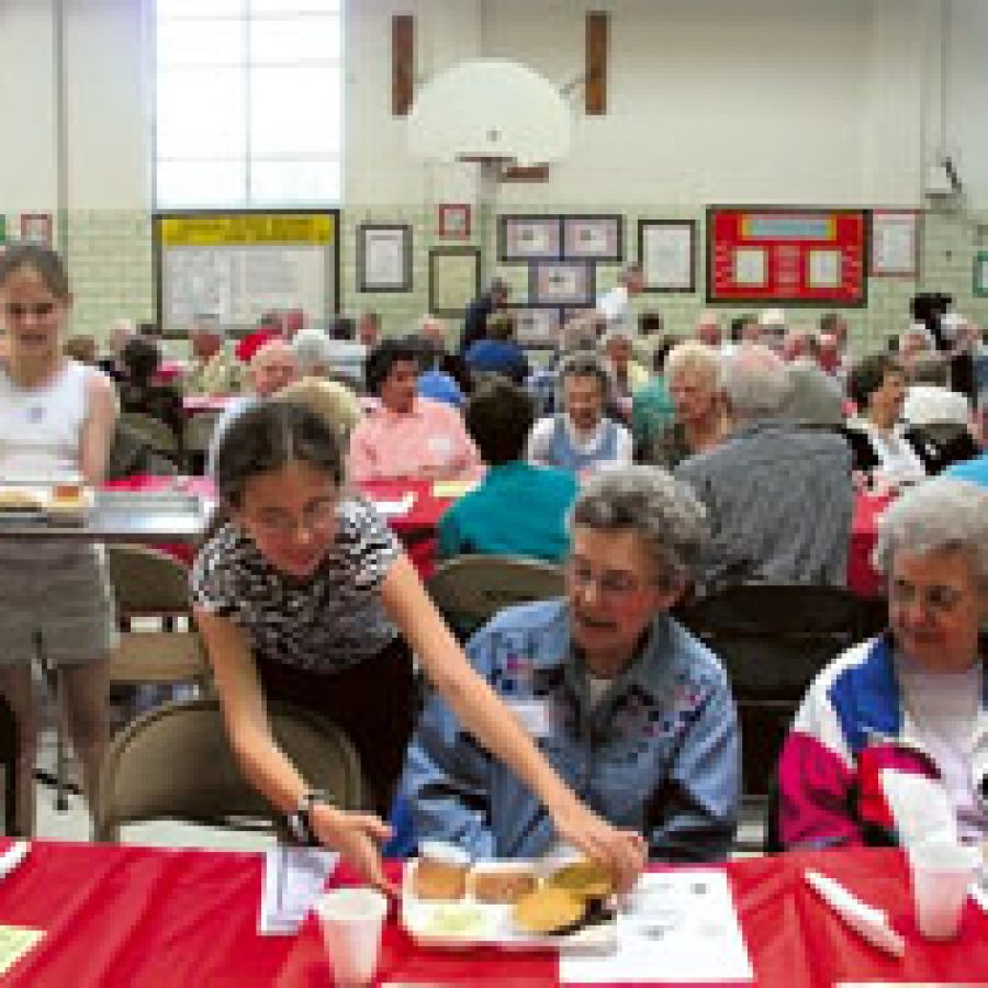 Bierbaum Accelerated School students serve lunch to their 60-Plus Club guests during the clubs annual barbecue.