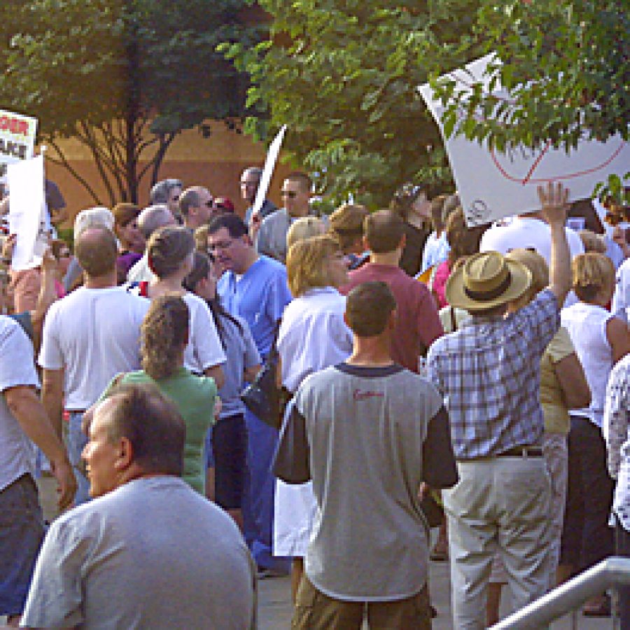 Hundreds of placard-bearing residents demonstrated outside Bernard Middle School after being shut out of a town-hall meeting on Aging in America sponsored by U.S. Rep. Russ Carnahan, D-St. Louis. Bill Milligan photo