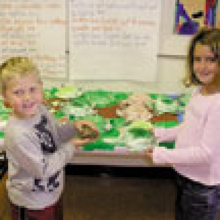 Six-year-old Joey Matthews holds the class turtle and and 6-year-old Jordan Michalski shows off the box turtle she made from a paper bowl. Both youngsters are in Karen Bridges first-grade class. 