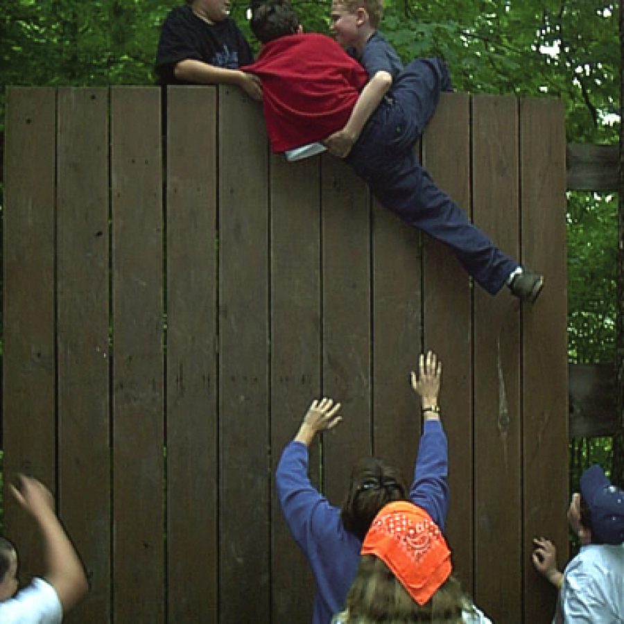 John Ketzner and Ian Wohlstadter help Jacob Smith climb over a 10-foot wall during the Outdoor Education program.